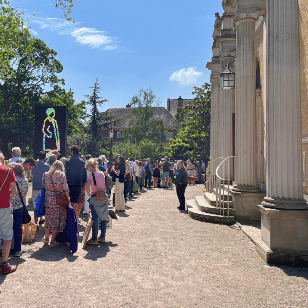 Visitors form a long line outside Pitzhanger Manor, eager to explore an acclaimed art exhibition.